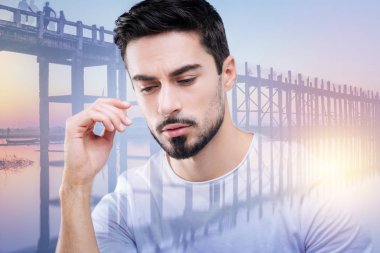 Süre oturan ve nehirde seyir huzurlu hissediyor adam genç sakallı