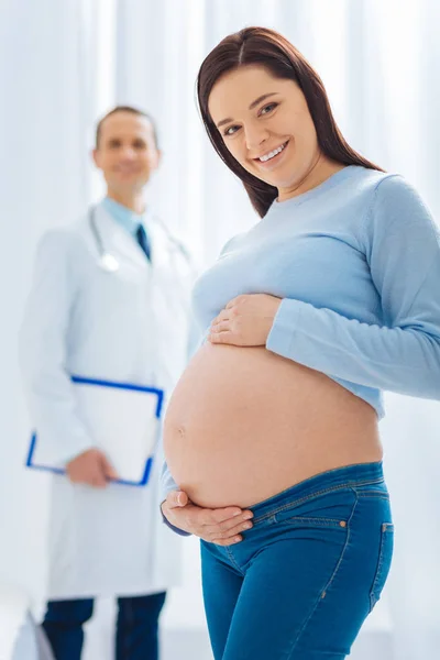 有吸引力的妇女显示她的婴儿腹部在照相机 — 图库照片