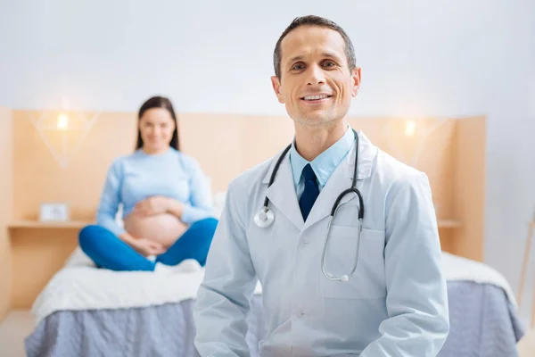 Especialista orgulhoso visitando sua paciente grávida — Fotografia de Stock