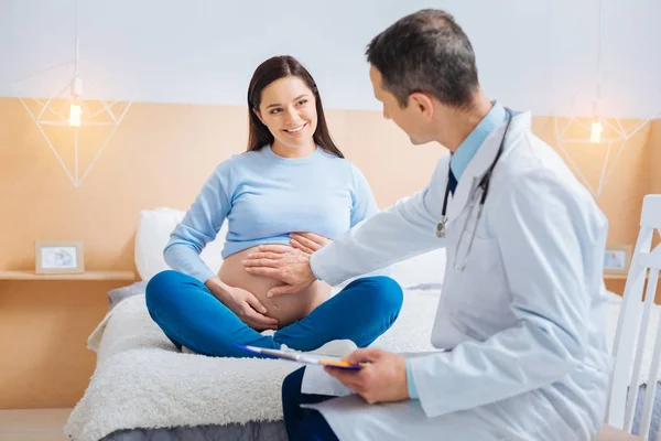 Encantado futuro mamãe consultoria com seu médico — Fotografia de Stock