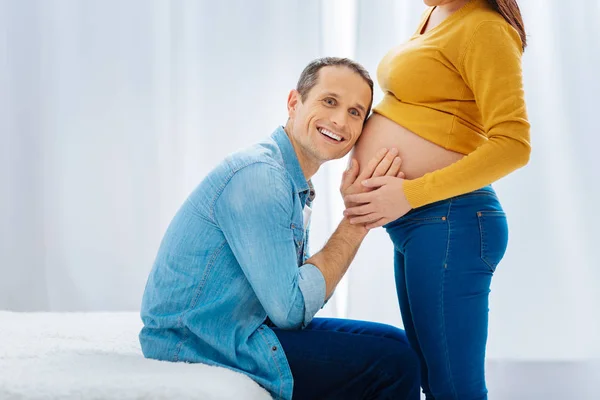 Happy man putting head on the tummy of his wife — Stock Photo, Image