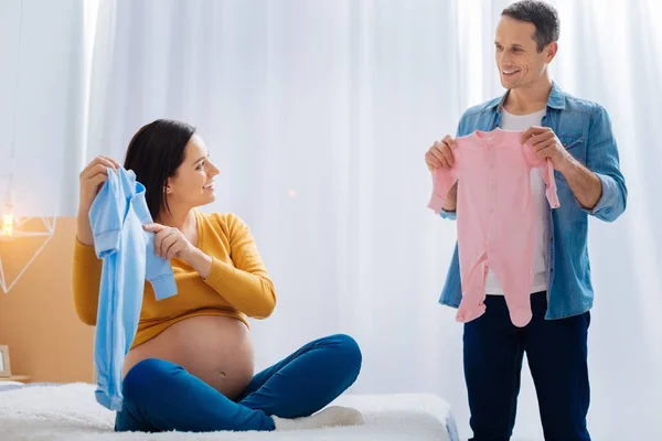 Delighted man demonstrating clothes to his woman — Stock Photo, Image