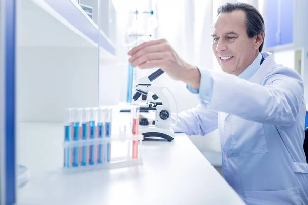 Happy positive scientist taking a test tube — Stock Photo, Image