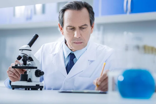 Serious professional scientist writing a report — Stock Photo, Image