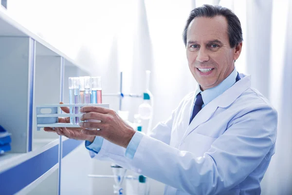 Happy smart doctor taking test tubes — Stock Photo, Image