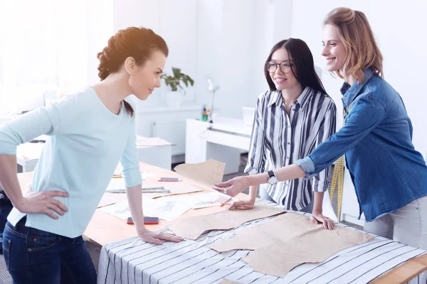 Amistosos sastres compartiendo piezas de trabajo — Foto de Stock