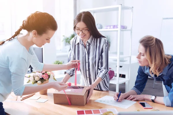 Pleasant colleagues covering the parcel for their client — Stock Photo, Image