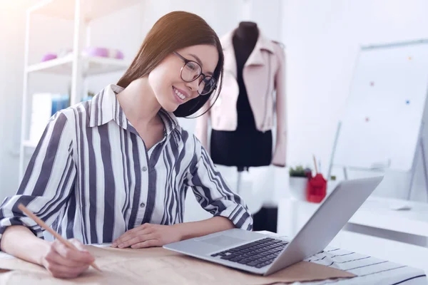 Allegro giovane dipendente guardando lo schermo del suo computer portatile — Foto Stock