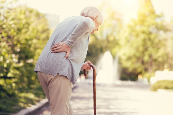Sad leeftijd vrouw leunend op de wandelstok — Stockfoto