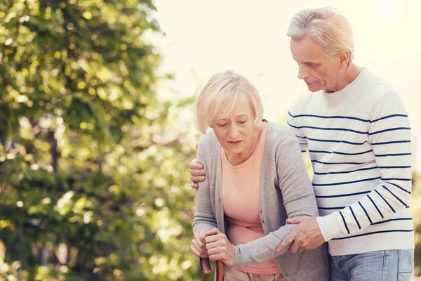 Agradable hombre cariñoso ayudando a su esposa — Foto de Stock