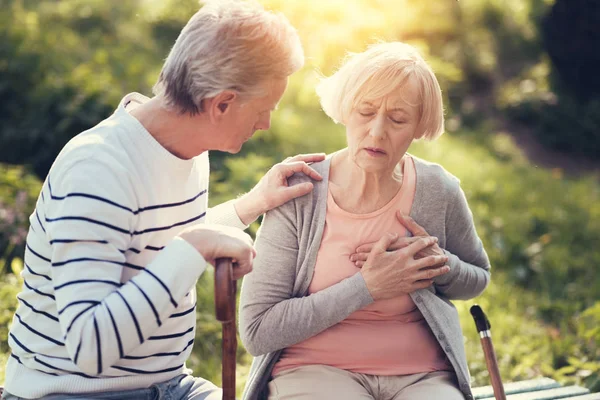 Unhappy aged woman holding her chest — Stock Photo, Image