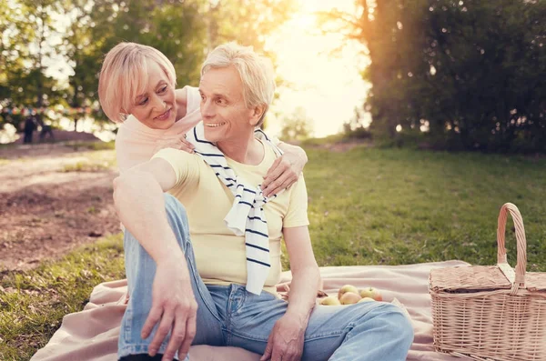 Задоволена літня жінка сидить за чоловіком — стокове фото