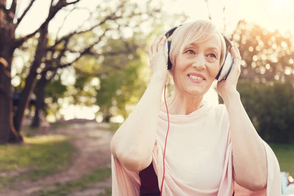 Glad glad kvinna som bär hörlurar — Stockfoto