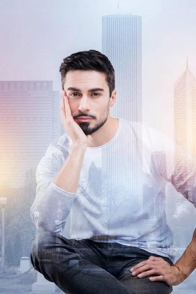 Tired young man sitting with his head resting on his right hand — Stock Photo, Image