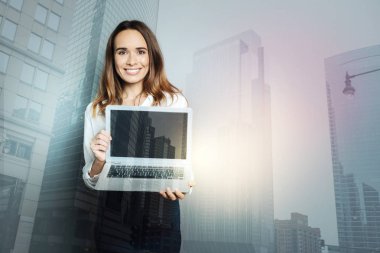 Bir dizüstü bilgisayar tutan mutlu profesyonel kadın