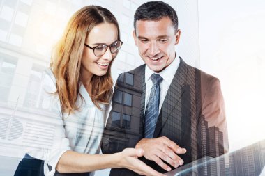 Bir dizüstü bilgisayar tutan iki mutlu gülümseyen iş arkadaşları