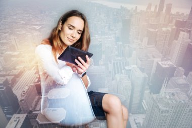 Gülümseyen kadın onun tablet ekranına bakarak