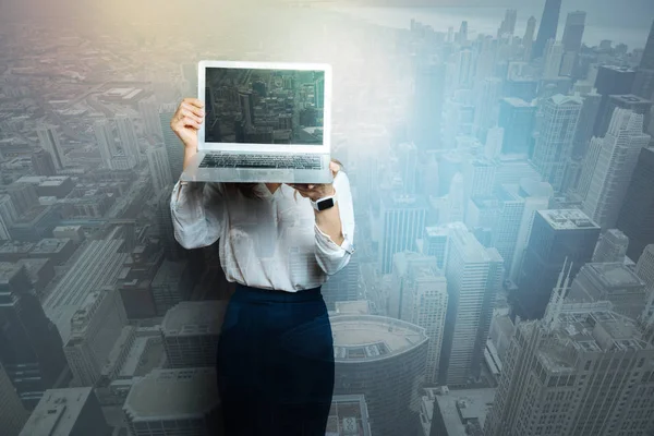 Positiv trevlig affärskvinna som står med en bärbar dator — Stockfoto