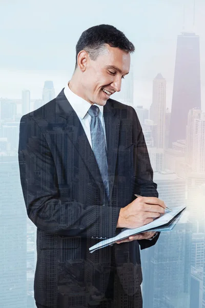 Pleasant happy businessman writing a plan — Stock Photo, Image