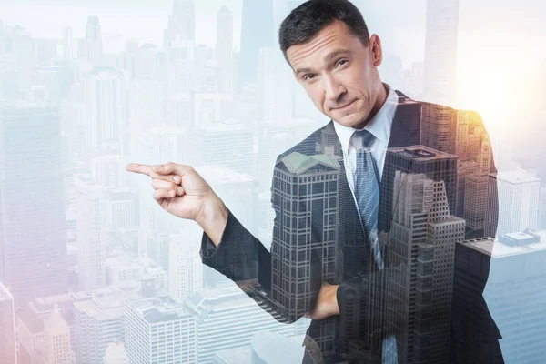 Pleasant young man pointing to the right — Stock Photo, Image