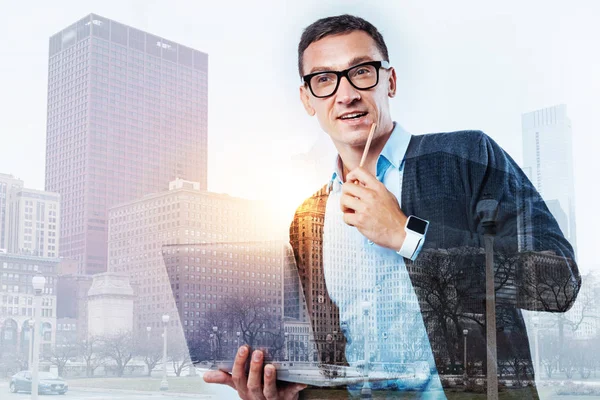 Hombre sonriente con gafas sosteniendo un portátil — Foto de Stock