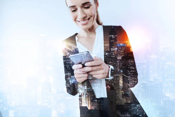 Feliz mujer sonriente sosteniendo un teléfono inteligente — Foto de Stock