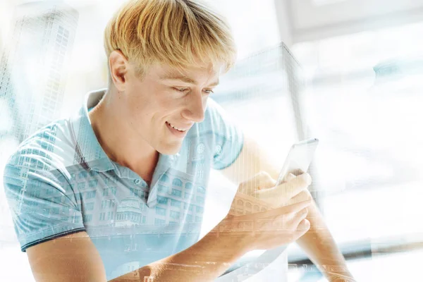 Curioso hombre guapo sosteniendo el teléfono móvil — Foto de Stock