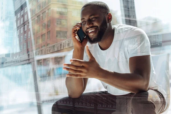 Jovem positivo falando no celular — Fotografia de Stock