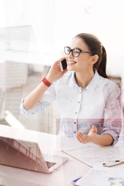 Vidám fiatal nő beszél telefonon az irodában — Stock Fotó