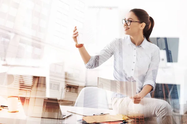 Joyeux jeune femme travaillant avec des papiers dans le bureau — Photo