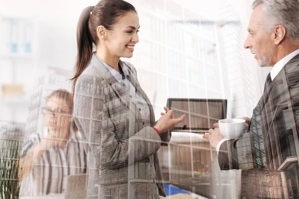 Positieve jonge vrouw het delen van ideeën met haar baas op kantoor — Stockfoto