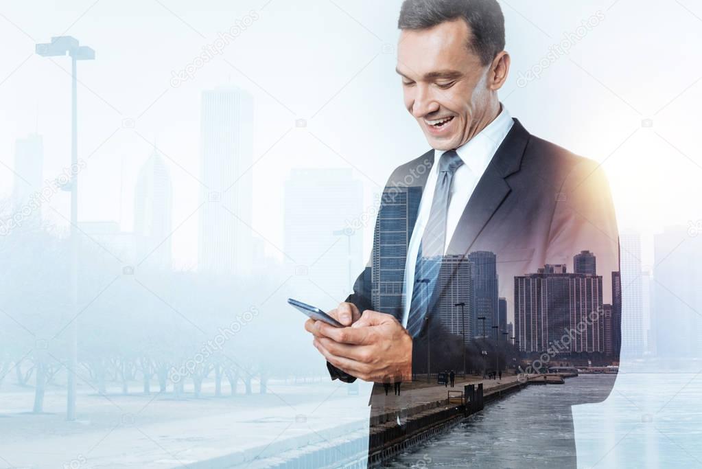 Delighted businessman getting a message on his smart phone