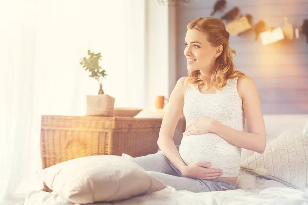 Positive schwangere Frau, die ihren Bauch berührt — Stockfoto