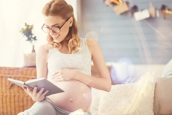 Positive schwangere Frau liest Buch — Stockfoto