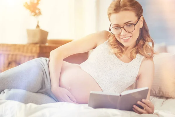 Glad glad gravid kvinna läser bok — Stockfoto