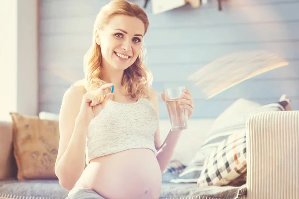 Gioiosa donna incinta che prende pillole — Foto Stock