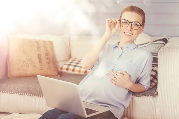 Vrolijke zwangere vrouw met laptop thuis — Stockfoto