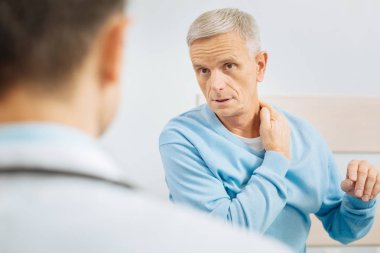 Güzel söz konusu adam boynuna dokunuyor