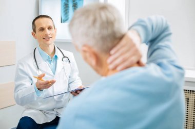 Neşeli deneyimli doktor hastası için konuşuyor