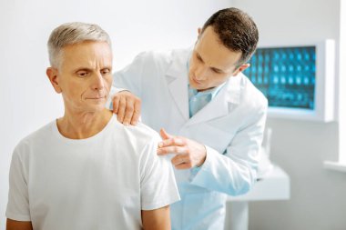 Ciddi akıllı doktor hasta omzunun bakarak