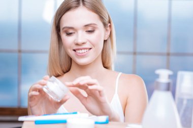 Neşeli kadın parmağını ile bazı krem alarak