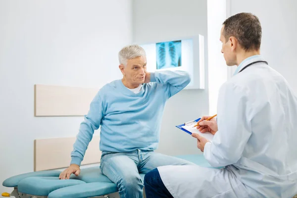 Agradable anciano sosteniendo su cuello — Foto de Stock