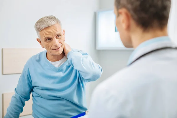 Nice aged man feeling pain in the neck — Stock Photo, Image