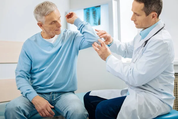 Netter alter Mann hält seinen Arm hoch — Stockfoto