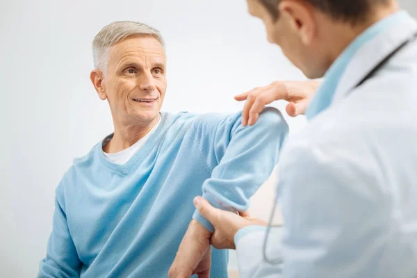 Alegre buen hombre doblando su brazo —  Fotos de Stock