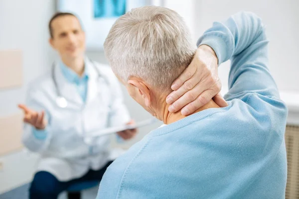 Nice aged man feeling pain in the neck — Stock Photo, Image