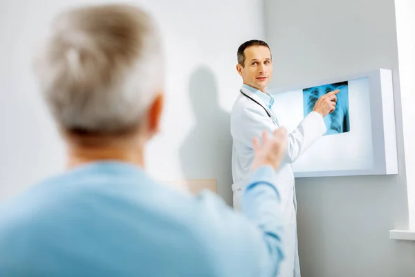 Smart przystojny lekarz, wskazując na obraz Xray — Zdjęcie stockowe