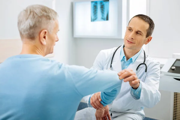 Хороший профессиональный врач держит пациентов за руку — стоковое фото