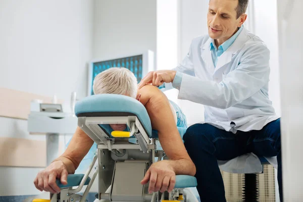 Profissional médico do sexo masculino tratando seu paciente — Fotografia de Stock