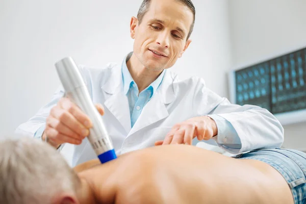 Médico inteligente alegre olhando para seus pacientes coluna vertebral — Fotografia de Stock